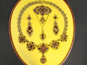 A XIX Century Georgian gold repoussé and canetille parure set with foiled garnets.