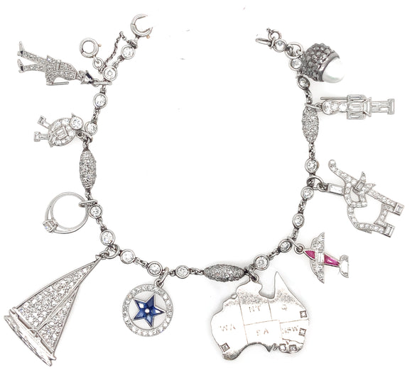 An Art Déco platinum diamond and precious stone bracelet with 10 charms.