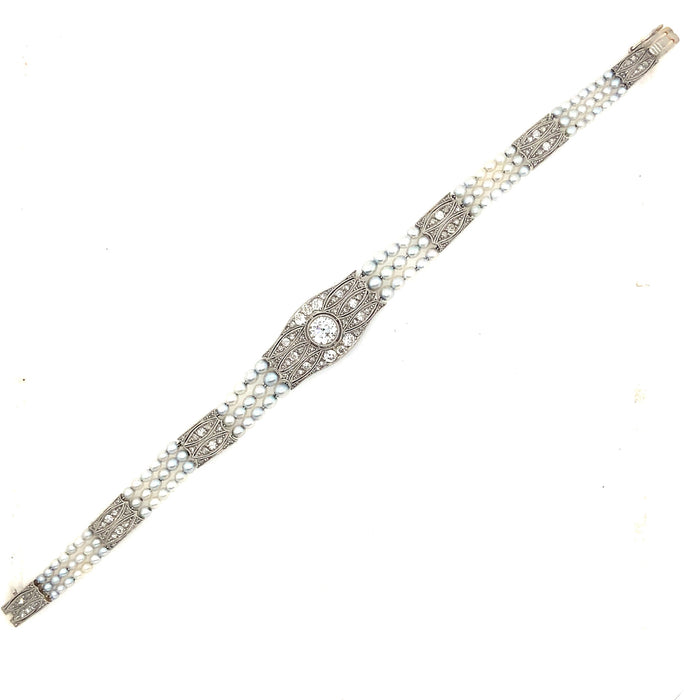 An Edwardian platinum, diamond and natural pearls bracelet