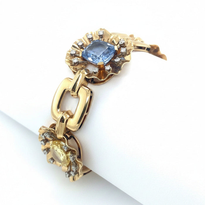 A yellow gold, diamond and yellow/blue sapphire bracelet. Period 1950 circa