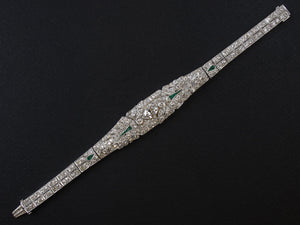 A platinum and diamond Art Deco bracelet set with a navette weighting around 0,90 carats ( J, VVS2 ) and several calibré emeralds. 1925.