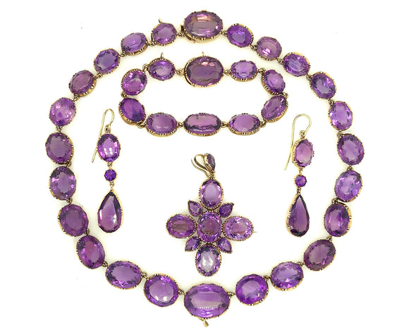 Antica parure in oro giallo e ametiste composta da una collana riviere un paio di orecchini pendenti un pendente cruciforme ed un braccialetto. 