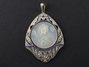 An Art Déco platinum, diamonds, sapphire and mother of pearl Virgin Mary pendant.