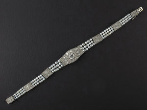 An Edwardian platinum, diamond and natural pearls bracelet