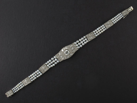 An Edwardian platinum, diamond and natural pearls bracelet