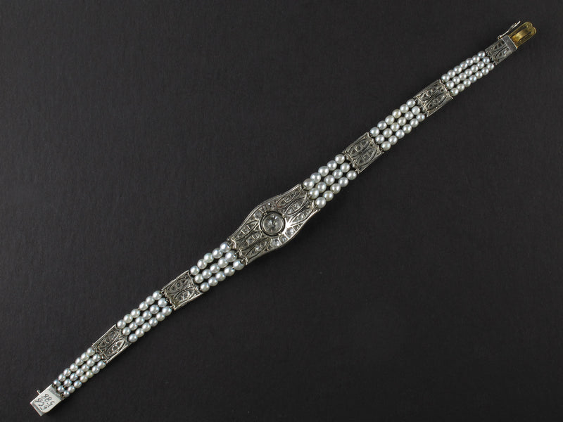 An Edwardian platinum, diamond and natural pearls bracelet