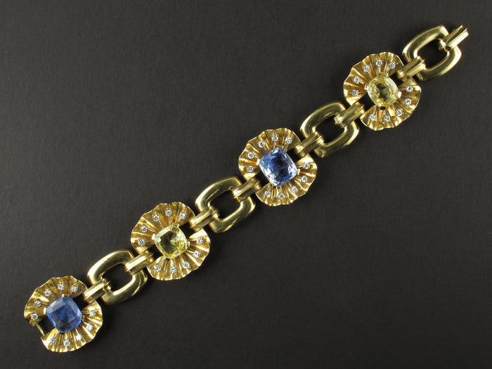 A yellow gold, diamond and yellow/blue sapphire bracelet. Period 1950 circa