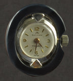 An Art Déco platinum diamond, onyx, coral and rock crystal lapel watch. Bucherer, Switzerland, 1925 c.a.