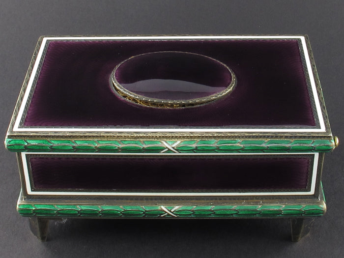 A silver-gilt singing bird automation box with guilloche in translucent violet and green enamel , the oval cover enamelled opening to reveal a singing feathered bird. Swiss 1960
