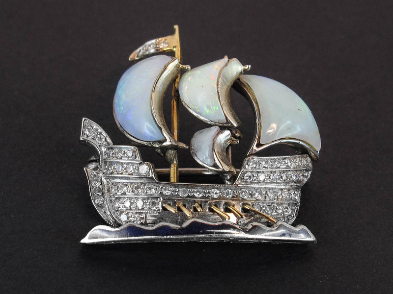 Spilla in platino, oro, diamanti e opale a forma di caravella con file sulle onde. 1930 ca 