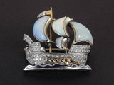 A platinum, gold, diamond and opal brooch in the shape of a caravel with rows on the waves. 1930 c.a.